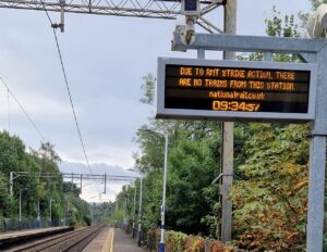 Overhead sign on platform with strike information