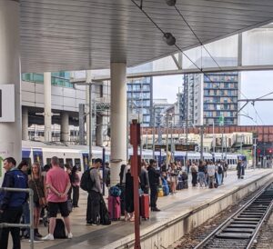 Busy rail platform with passengers and staff